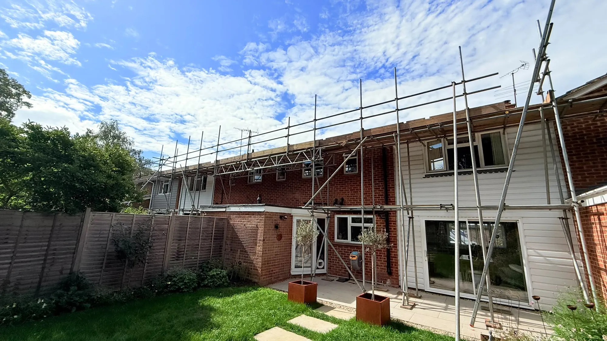 Scaffolding along the rear roofline of a terrace in Caversham, seen from the back garden